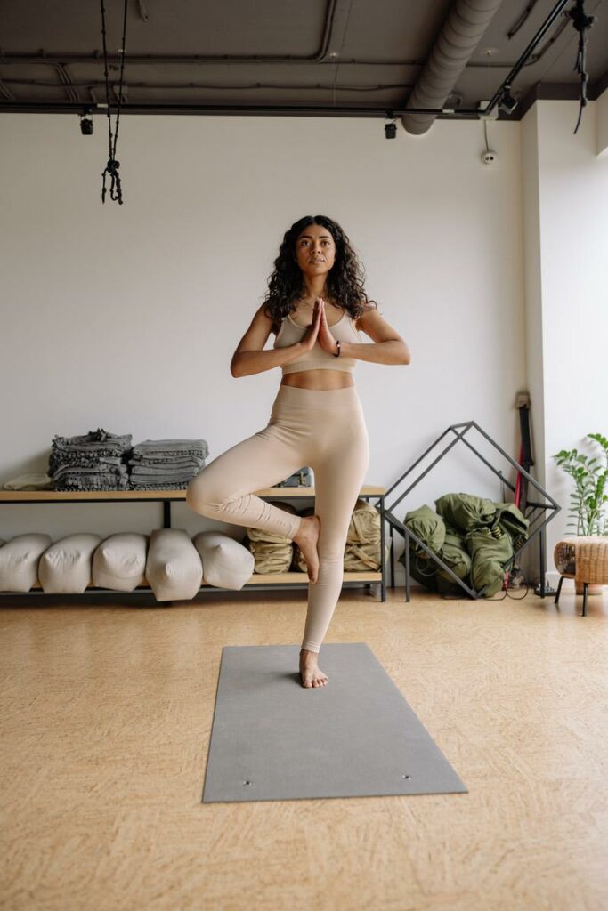 Person die Yoga macht, Joga, Yogamatte, Ausgeglichekeit, gemütlicher Raum, Ausgleich, Gleichgewicht